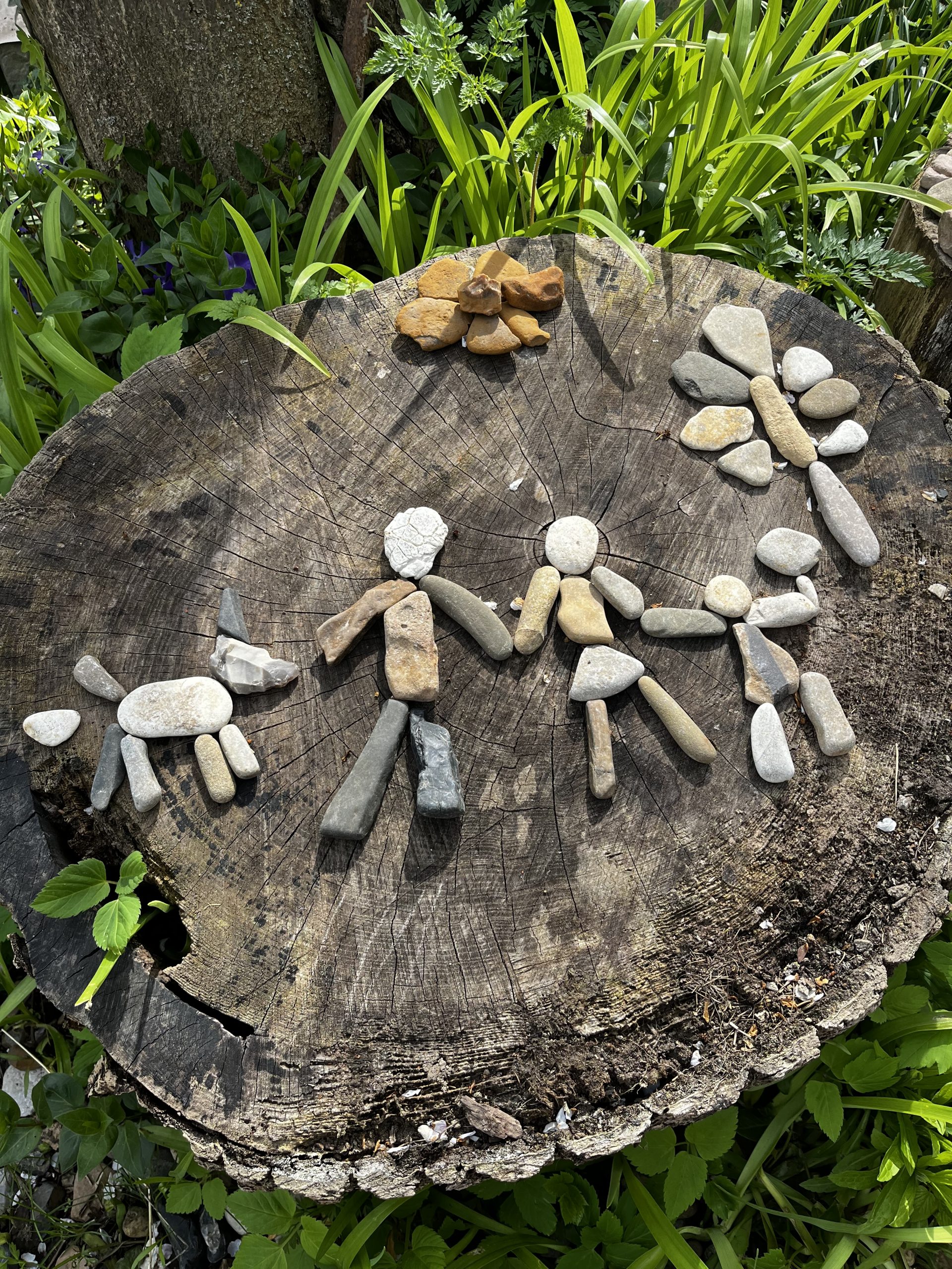 Aus Steinen gelegte Figuren bilden eine Gruppe